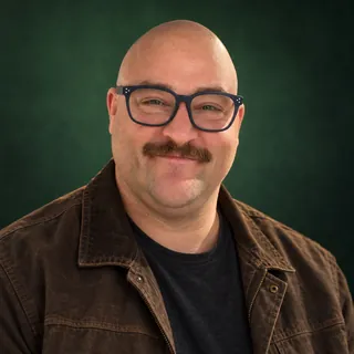 Joe Hill, head and shoulders, dark green backdrop